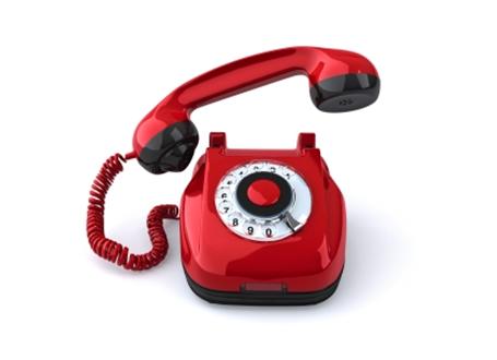 czerwony telefon z tarczą numeracyjną i odchyloną słuchawką
