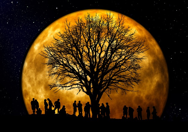 Drzewo na tle żółtego księżyca, pod drzewem postaci ludzkie