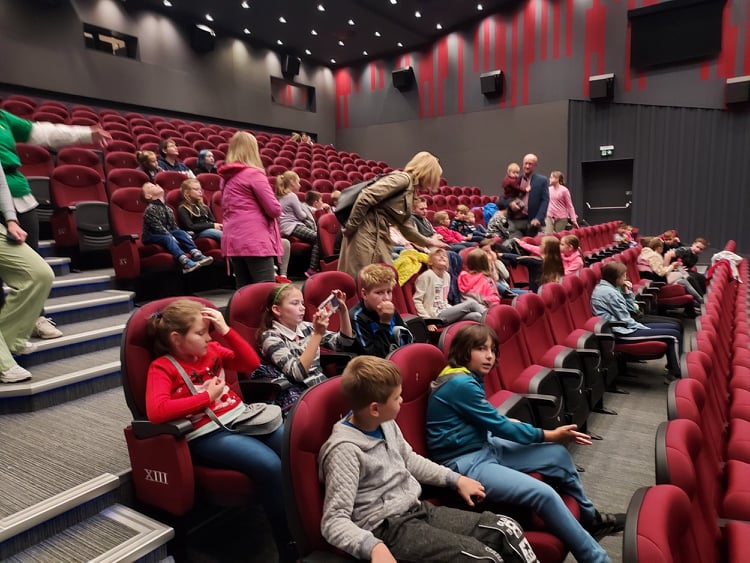 Dzieci z pieczy zastępczej siedzący w kinie na seansie