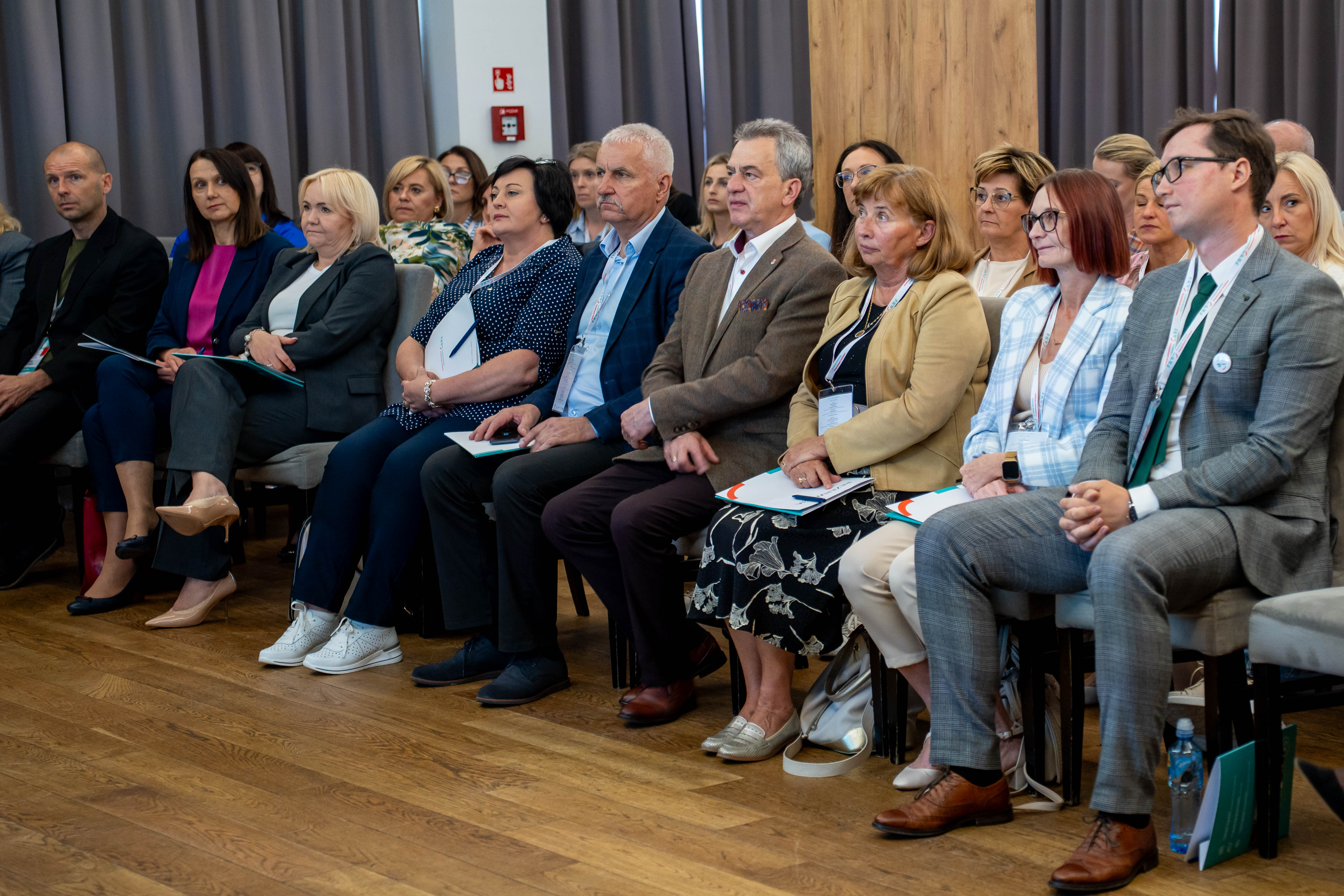 Mężczyźni i kobiety słuchający wykładów na konferencji