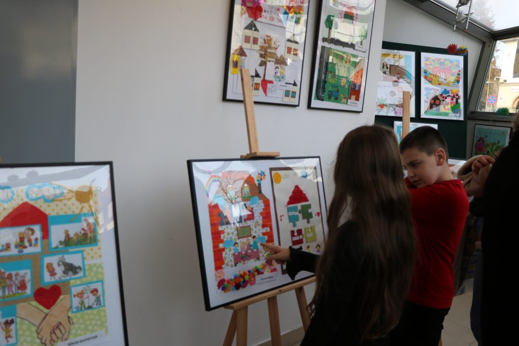 Nagordzeni 2 osoby dziewczyna i chłopiec oglądają prace na wystawie