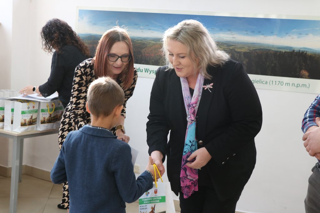 wicestarosta i dyrektor PCPR wręczają nagrodę chłopcu