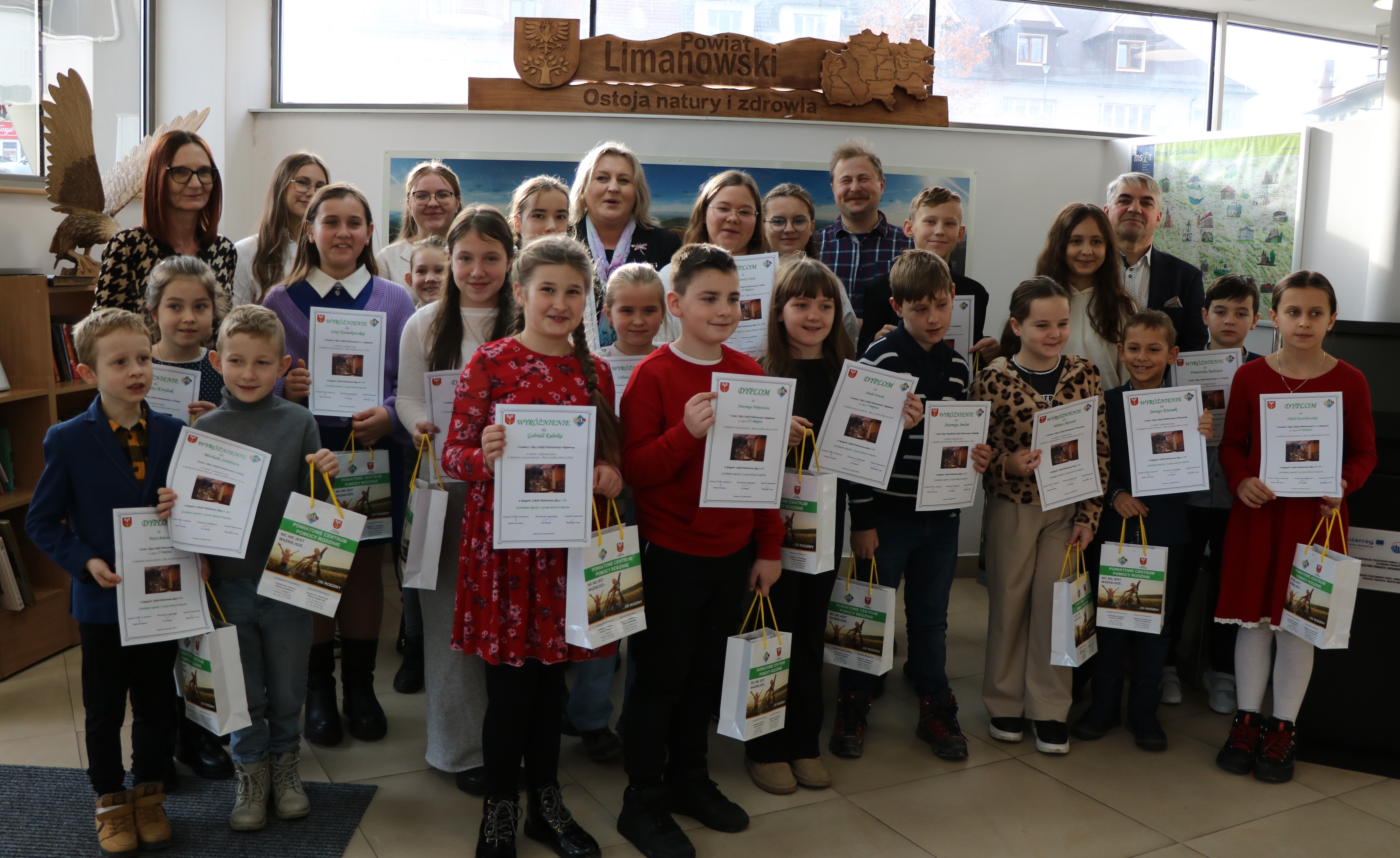 grupa dzieci z dyplomami i nagrodami pozująca do zdjęcia
