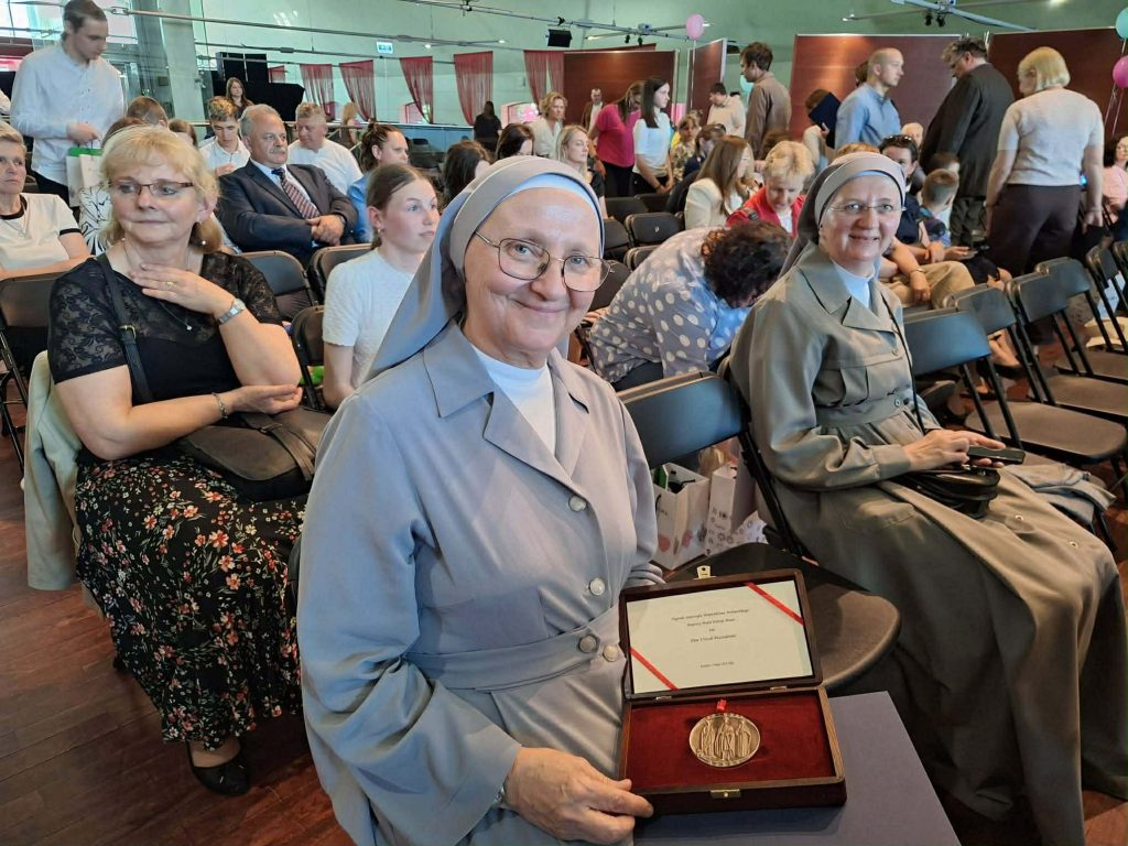 siostra zakonna siedzi na widowni i trzyma w ręce brązowy medal polonia minor