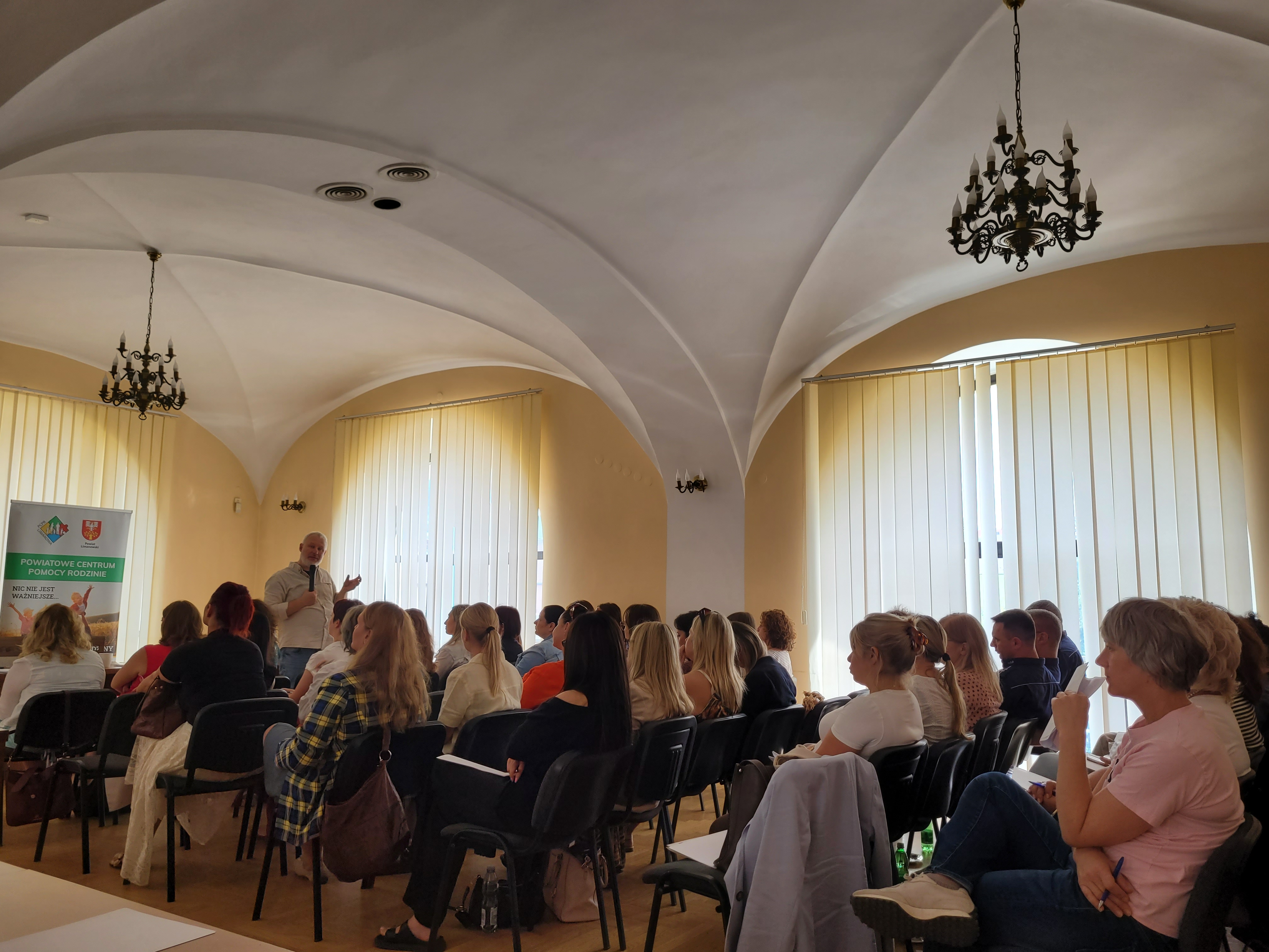 grupa osób siedząca na szkoleniu i słuchająca szkolenia